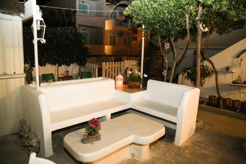 a white couch and a table with flowers on it at Marilena in Skala Eresou