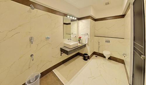 a large bathroom with a sink and a shower at Poppys Hotel Madurai in Madurai