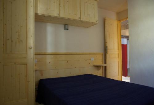 - une chambre avec un lit bleu et des placards en bois dans l'établissement Appart Ressachaux Morzine centre 2 à 3 pers calme vue jardin parking, à Morzine