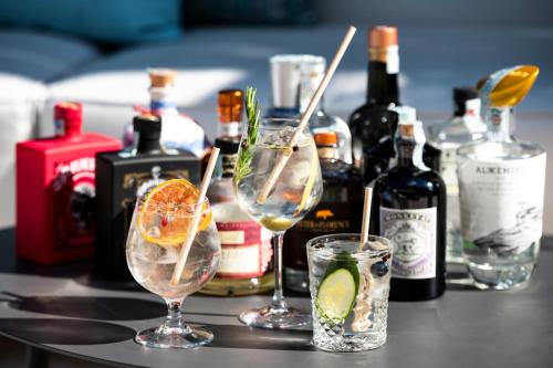 a table with two glasses and bottles of alcohol at Villa Rosa Hotel Desenzano in Desenzano del Garda