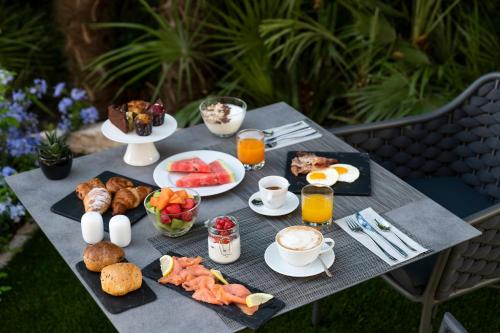 a table with breakfast foods and drinks on it at Villa Rosa Hotel Desenzano in Desenzano del Garda