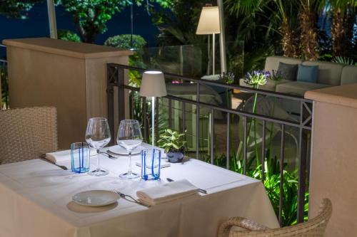 a table with wine glasses and napkins on a balcony at Villa Rosa Hotel Desenzano in Desenzano del Garda