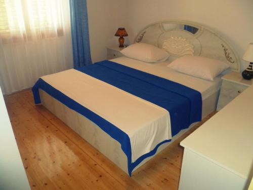 sypialnia z łóżkiem z niebieską i białą pościelą w obiekcie Apartments Kamenice w Neum