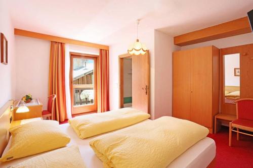 a hotel room with two beds and a window at Gasthof Albergo Neuwirt in Val di Vizze