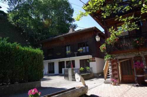 een kat die voor een huis zit bij Appart Ressachaux Morzine centre 2 à 4 pers calme vue jardin parking in Morzine