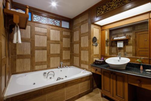 a bathroom with a tub and a sink at Khum Phaya Resort & Spa Boutique Collection in Chiang Mai