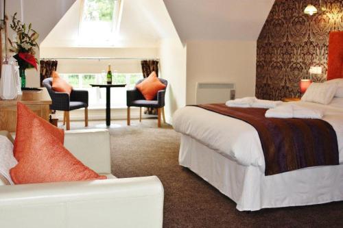 um quarto de hotel com uma cama, uma mesa e cadeiras em Hockley House em Hockley Heath