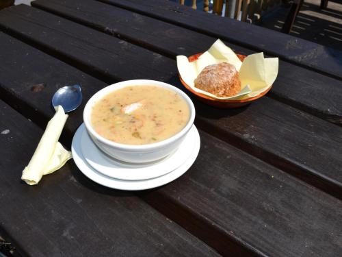 a bowl of soup and a bowl of bread on a wooden table at Oliver's Seafood Bar, Bed & Breakfast in Cleggan