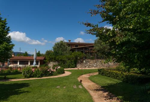un jardin avec une maison en arrière-plan dans l'établissement Locanda LA VALLE, à Castelnuovo Magra