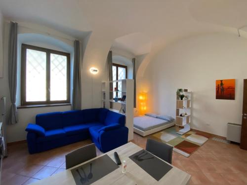 un soggiorno con divano blu e tavolo di Appartamento Corte nel Grano a Rovereto