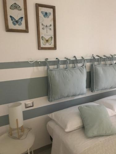 a bedroom with a bed with blue and white pillows at Lady Hamilton B&B in Feletto
