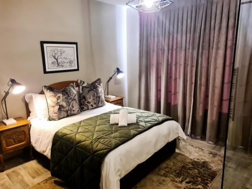 a bedroom with a bed and a window with curtains at Diamantvallei Landgoed in Rayton