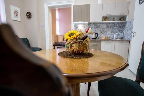 a table with a vase with a sunflower on it at Apartments Borovo in Subotica