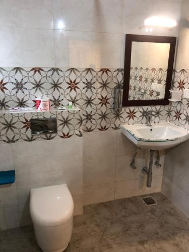 Un baño con inodoro, lavabo y espejo. en Family Friendly Studio Apartment -3, en Bangalore