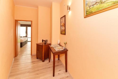 a hallway with a table and a painting on the wall at Hotel zum dicken Baum in Mayen
