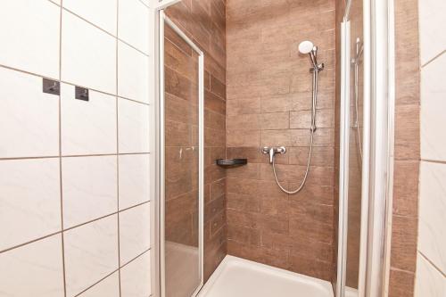 a shower with a glass door in a bathroom at Hotel zum dicken Baum in Mayen