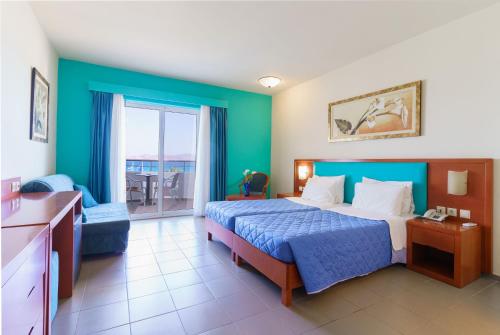 a hotel room with a bed and a balcony at Kos Palace in Tigaki