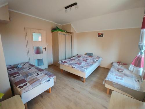 a room with two beds and a table in it at Apartament Nemo in Rowy