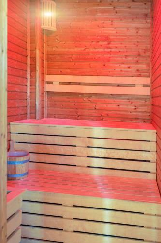 a wooden sauna with a red and white wall at Casa Tisa in Băile Olăneşti