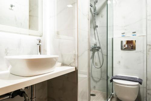 biała łazienka z umywalką i prysznicem w obiekcie Soñar en el mar w mieście Himara