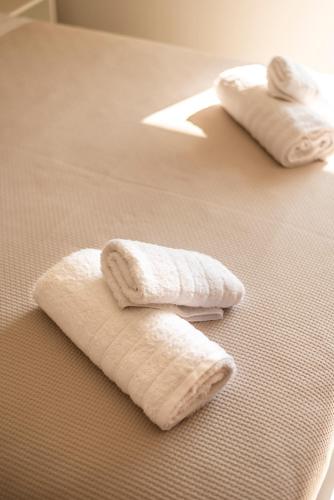 two white towels sitting on top of a bed at Soñar en el mar in Himare
