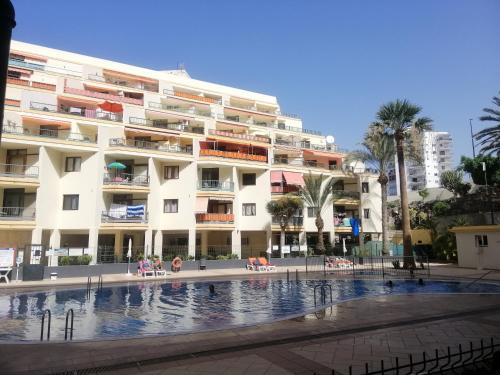 a large building with a swimming pool in front of it at Los Cristianos El Carmen in Los Cristianos