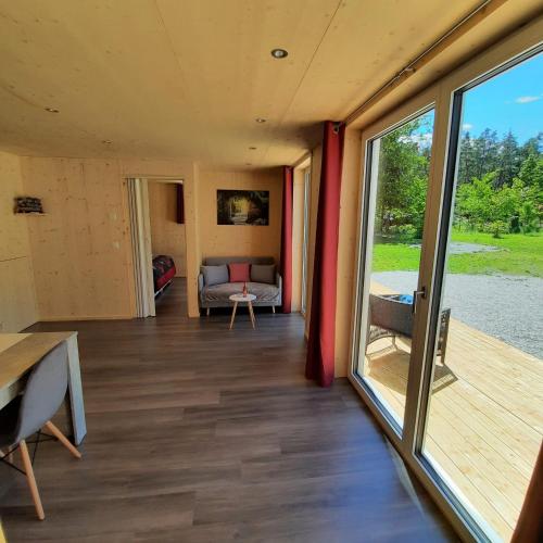 un soggiorno con divano e una grande finestra di Aktien 11 / A=obere Wohnung / B=untere Wohnung a Sils im Domleschg