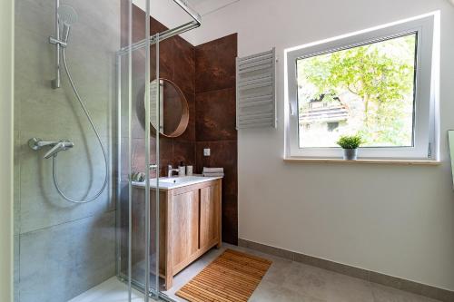 een badkamer met een douche, een wastafel en een raam bij Widokówka Zacisze in Brodnica Dolna