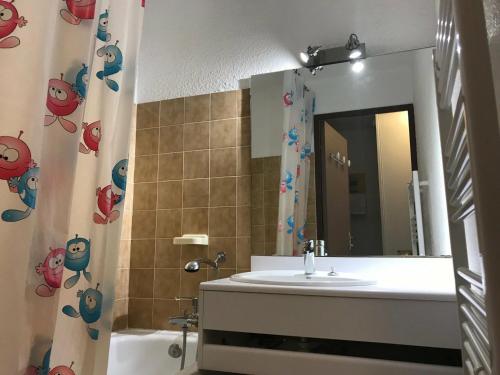 ein Badezimmer mit einem Waschbecken, einem Spiegel und einer Badewanne in der Unterkunft Appartement Montgenèvre, 2 pièces, 6 personnes - FR-1-445-94 in Montgenèvre