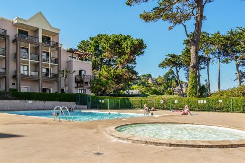 a swimming pool with people playing in it at Résidence Pierre & Vacances L'Archipel in Perros-Guirec