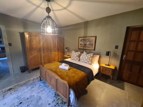 a bedroom with a large bed and a pendant light at Diamantvallei Landgoed in Rayton