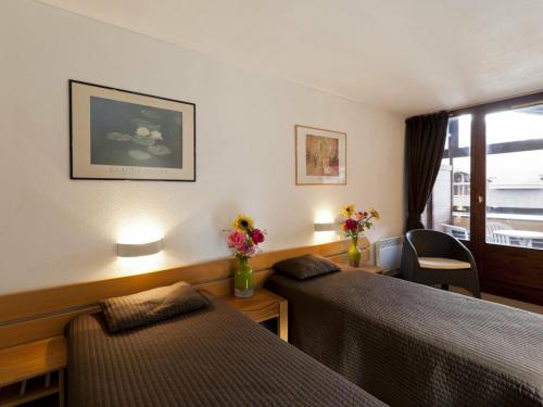um quarto de hotel com duas camas e uma janela em Studio Brides-les-Bains, 1 pièce, 4 personnes - FR-1-512-144 em Brides-les-Bains