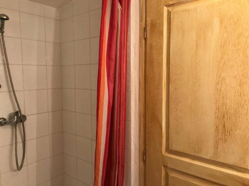 uma casa de banho com uma cortina de chuveiro vermelha. em Studio Montgenèvre, 1 pièce, 3 personnes - FR-1-445-137 em Montgenèvre