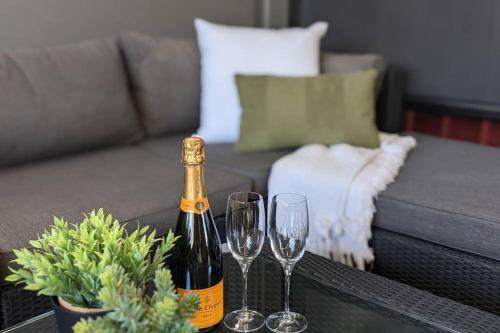 a bottle of wine and two wine glasses on a table at Central 3 bedroom, 2 bath home in Albury