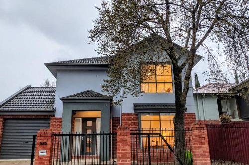 a white house with a fence in front of it at Central 3 bedroom, 2 bath home in Albury