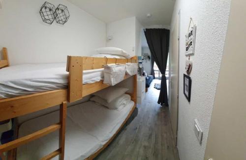 - une chambre avec 2 lits superposés et un couloir dans l'établissement Studio 2 alpes, proche lac buissonnière, ménage inclus, balcon, parking, à Les Deux Alpes
