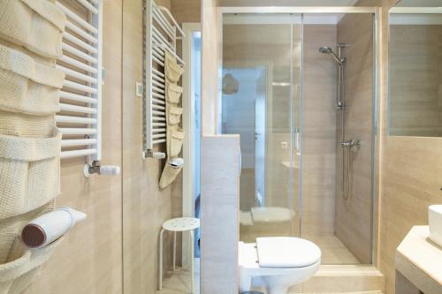 a bathroom with a toilet and a glass shower at Apartamenty In Jurata Ratibora 66 in Jurata