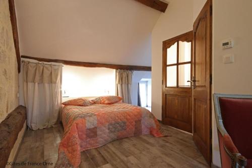 um quarto com uma cama e uma janela em Gîtes dans le Perche, Le Forest em Colonard-Corubert