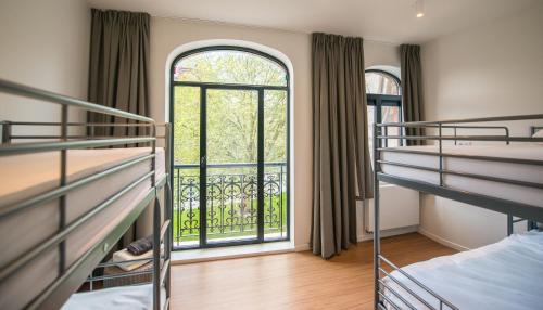 a room with two bunk beds and a window at Villa Fluisterbos met gratis parking in Ostend