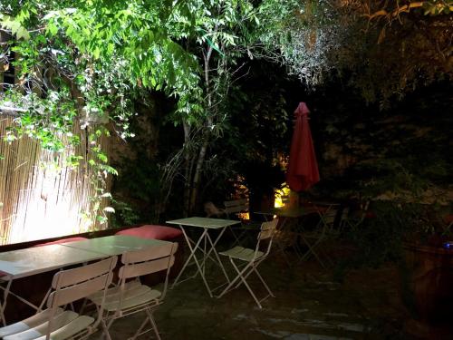 a patio with a table and chairs and an umbrella at Hôtel Saint Louis in Aigues-Mortes