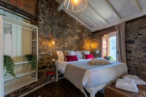 a bedroom with a bed in a brick wall at La Civera - Nesso Lake Como by Rent All Como in Nesso