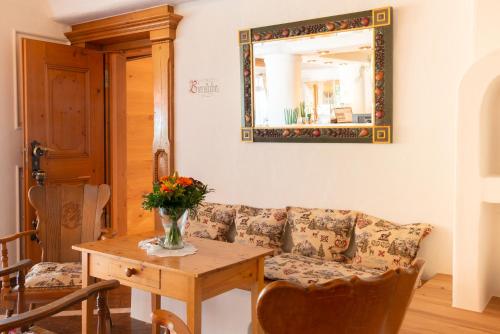 a living room with a couch and a table with a mirror at Landhaus Wacker in Wenden