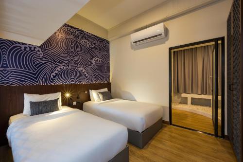 a hotel room with two beds and a window at Maldives Beach Resort in Chao Lao Beach