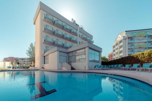 a hotel with a swimming pool in front of a building at Hotel Imperiale in Cattolica
