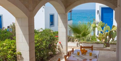 un patio con mesa y vistas al océano en Pension Panorama en Kalamaki