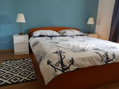 a bedroom with a bed with an anchor blanket at Apartmani Ljuba in Rogoznica