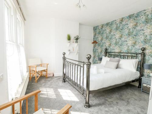 een slaapkamer met een bed met bloemenbehang bij Coastal Retreat in Weymouth