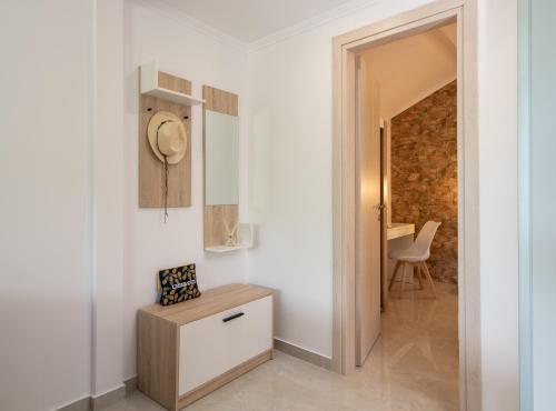 a white hallway with a table and a chair at Estell apartments in Sykia Chalkidikis