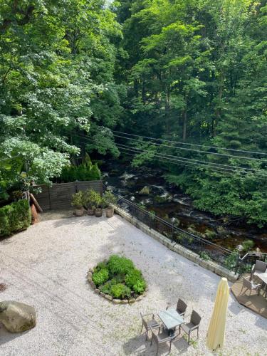 a patio with tables and chairs next to a river at Willa 654 in Szklarska Poręba