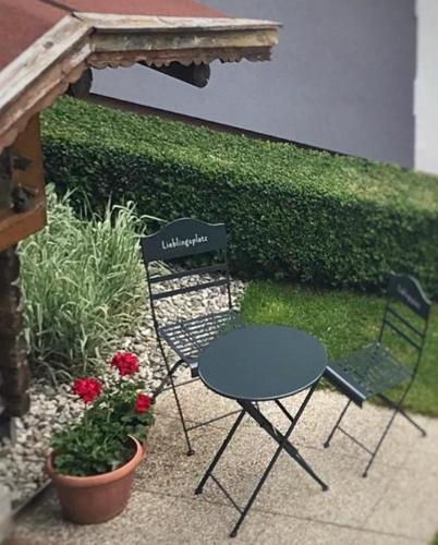two chairs and a table and a table and a plant at Wittner's in Söll
